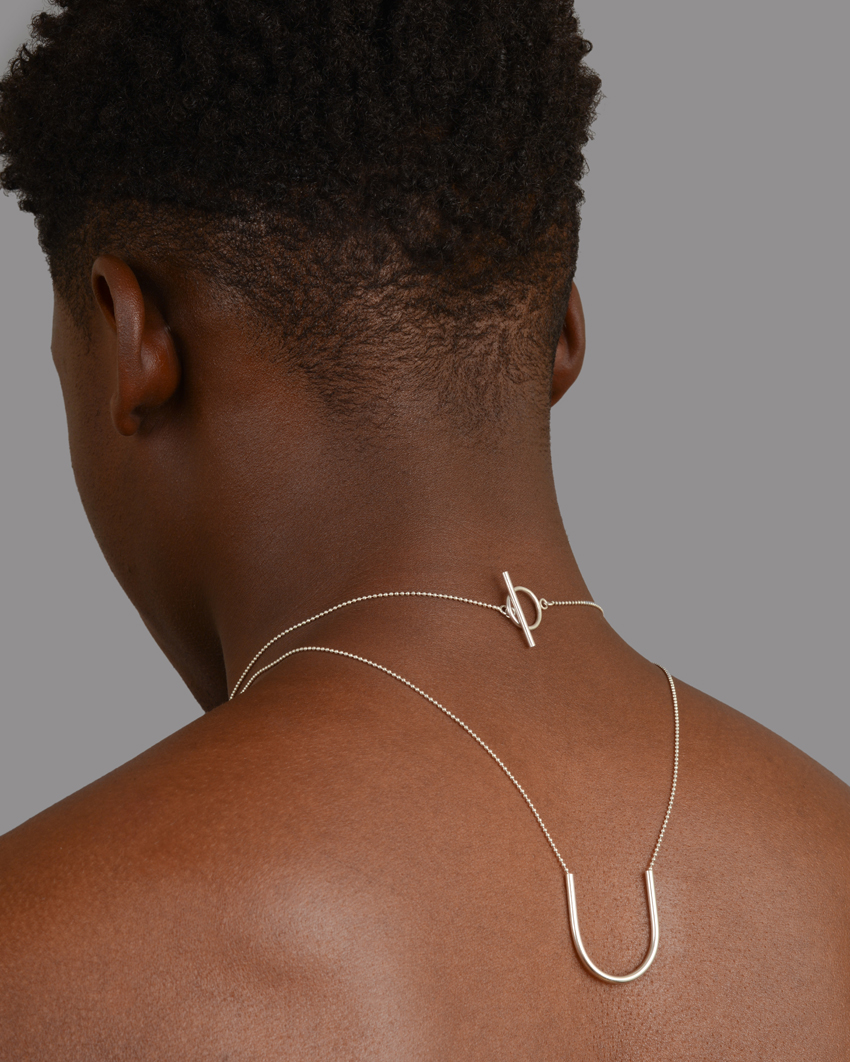 Akvile Su U Shape Pendant in recycled silver worn over model's back