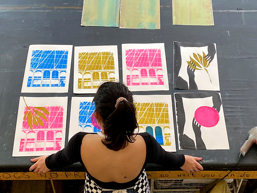 an image of a maker in front of prints by Blessed Unrest