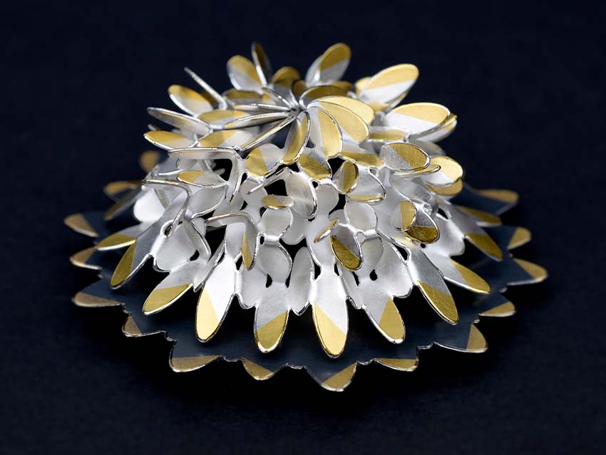 The Circular Oval Flower Brooch by Misun Won seen from above on black background