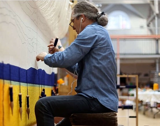 man working on a tapestry in dovecot studios
